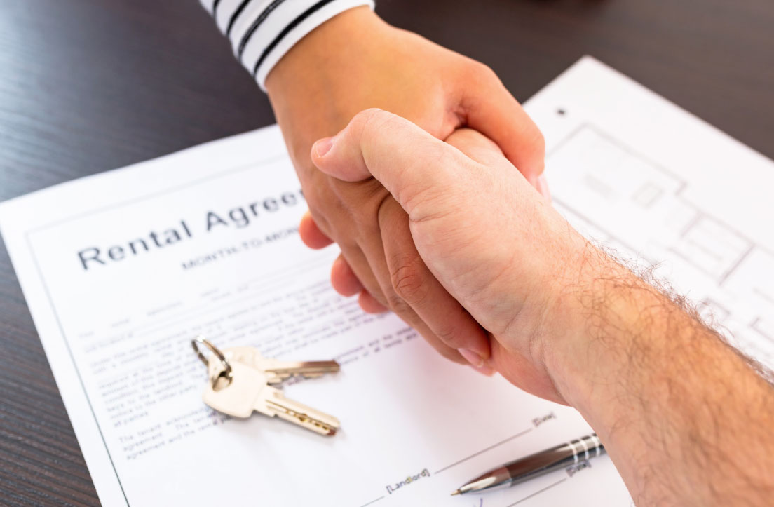 hands shake over rental agreement